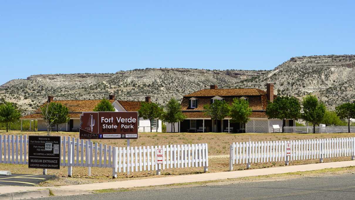 White picket fence with Fort Verde State Park sign in front of historic homes