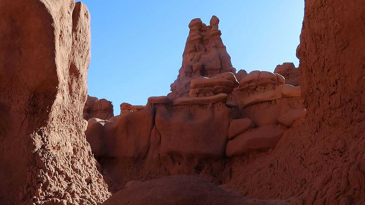 Canyon of red hoodoos against blue sky